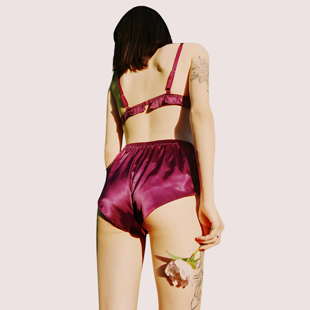 Back view of pure silk bra and shorts set in plum wine, showing adjustable straps and high-waisted silk shorts with a smooth glossy finish.