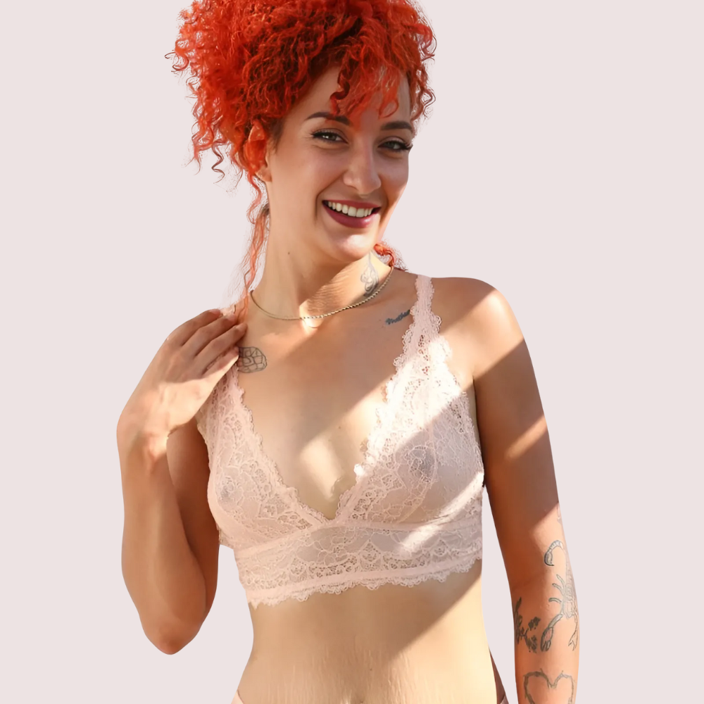 French-Inspired Premium Bralette Gift Box – French Daina Signature bralette in soft blush lace, front view featuring a smiling model with curly red hair and delicate floral lace details. KozyKlicks premium lingerie.
